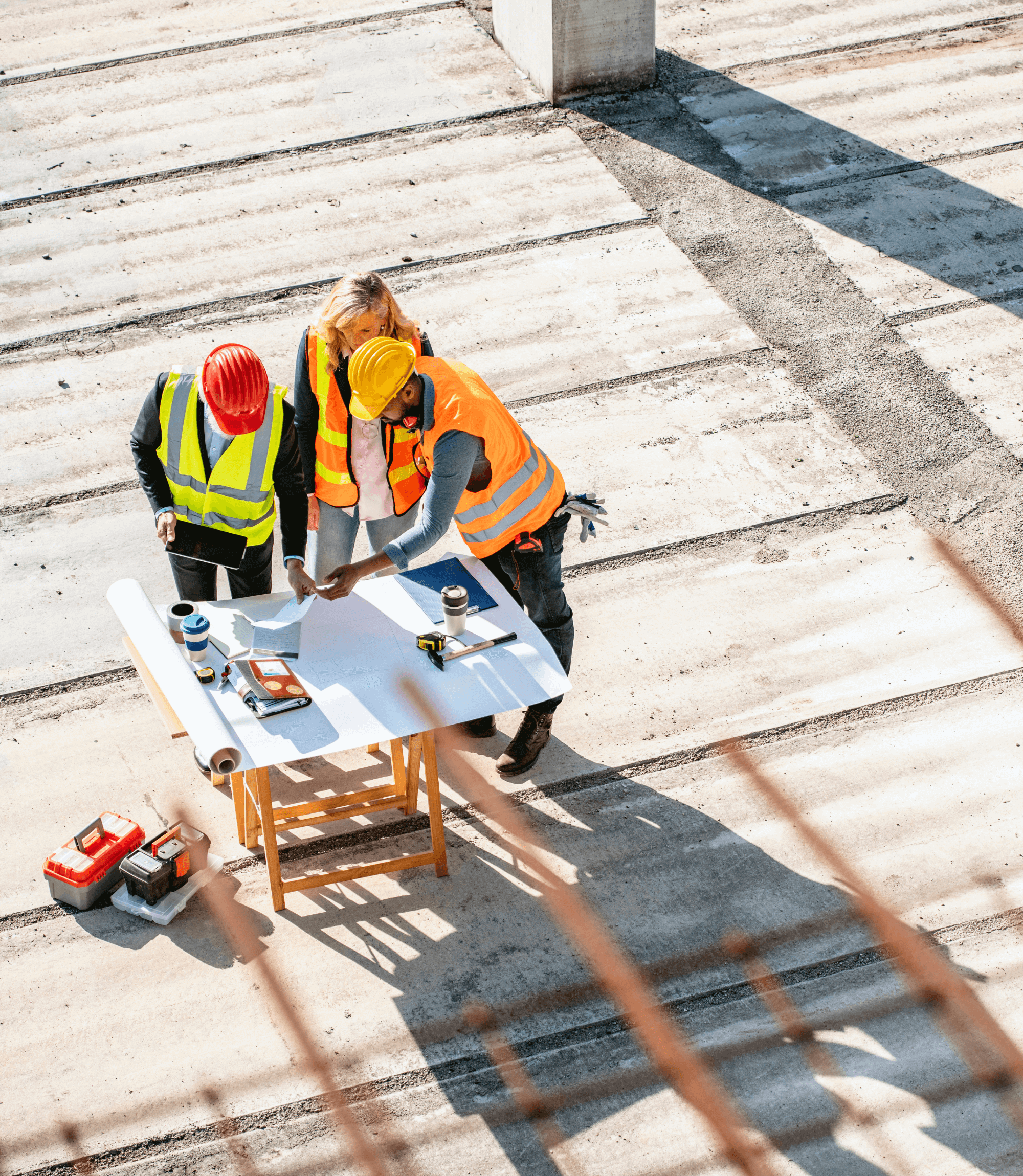 3 individuals in safety gear at a project site, project planning