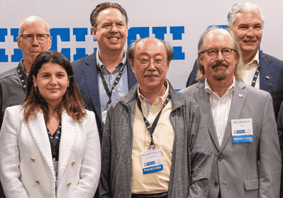 6 people standing side by side in front of a background with CII's logo